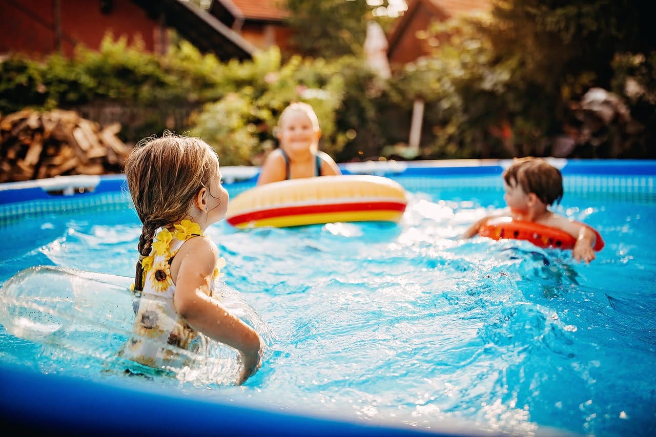 A group of kids playing in an inflatable pool.