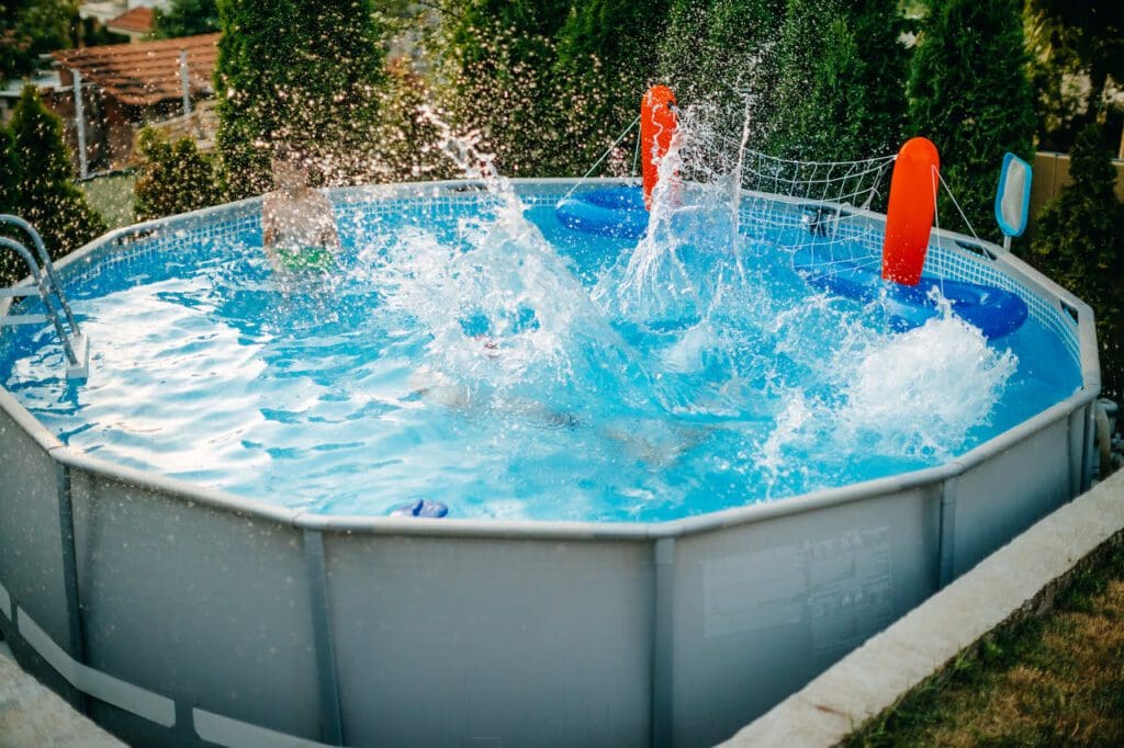 A pool with two people in it and water splashing.