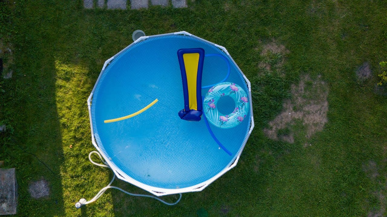 A blue and yellow frisbee in the grass.