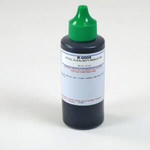 Chemical bottle with green cap on table.