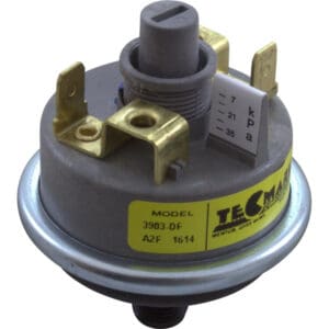 Gray and brass pressure switch component.