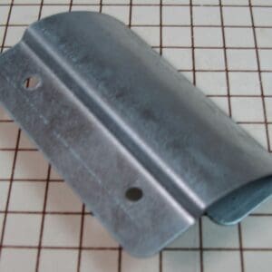 Metal bracket on grid-patterned background.