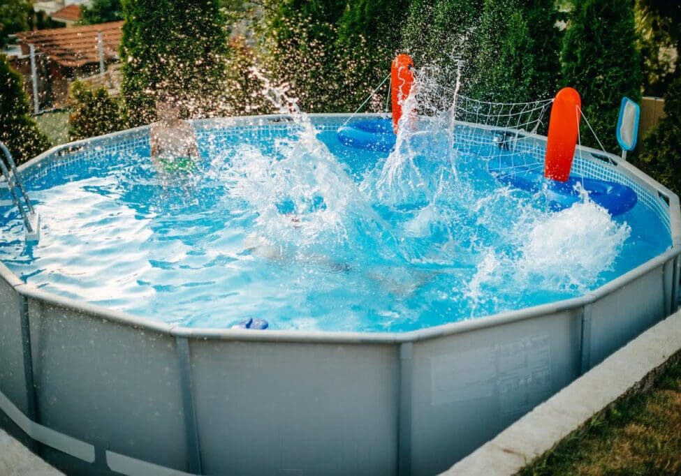 A pool with two people in it and water splashing.